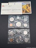 Both 1979 and 1980 sealed coin sets with COA and envelope visible