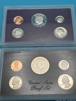 Front view of both proof sets showing obverse sides of coins