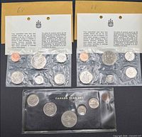 Overall view showing two 1968 pliofilm sets, brown envelopes, and one 1969 cardboard year set