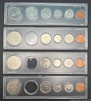 Four plastic snap-lock coin sets, three with empty middle slot, one complete