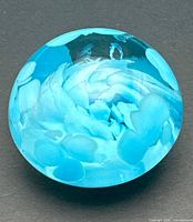 Top view of blue art glass paperweight showing internal swirl pattern