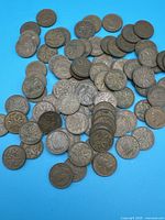 Spread of numerous Canadian 1 cent coins on blue background