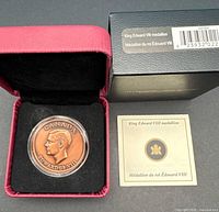 Medallion in red clamshell case with certificate and outer sleeve