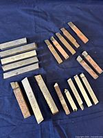 All lathe tool bits laid out on blue cloth