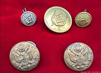 All five buttons displayed on red cloth