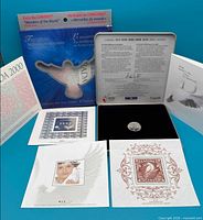 Outer sleeve, presentation tin, certificate, three souvenir stamp cards and medallion displayed