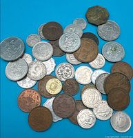 Pile of mixed world coins on blue background
