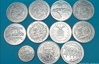 Group shot of 11 aluminium tokens plus nickel for scale