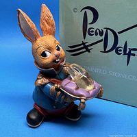 Front view of PenDelfin Charming figurine beside retail box