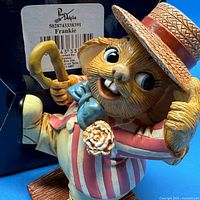 Close-up of Frankie figurine showing facial details, clothing and partial box label with barcode and name