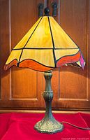 Full view of stained glass table lamp on red cloth