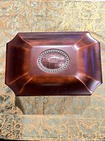 Top view of dark brown wooden jewelry box with oval medallion