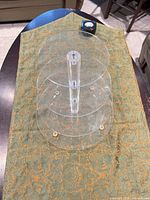 Full view of assembled clear acrylic stand on fabric