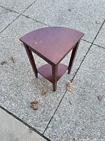 Full view of triangular corner side table showing top and legs