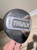 Club head top view showing TRIAX branding, loft, wear