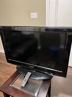 Front view Toshiba 32" TV on stand with remote