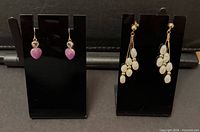 Both earring pairs displayed on black stands