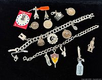 All charms and bracelets laid out on black background