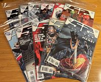 Front covers of multiple 52 issues fanned, showing Weeks 1-4