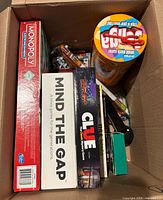 Box interior showing multiple board games and cylindrical game
