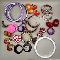 All jewelry pieces laid out including bangles, multiple earring pairs, single earring and heart brooch