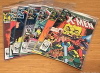Seven Uncanny X-Men comics fanned out, bagged, front covers visible