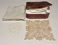 Box with stacked handkerchiefs, folded gauze cloth, round and square lace doilies