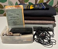 Stack of five wool fabric lengths, two instruction manuals, attachments case and cord