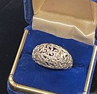 Sterling silver filigree ring resting in blue display box