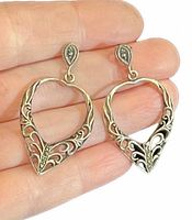 front view of both heart dangle earrings on hand