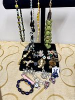 Full lot overview on display stand showing necklaces and grouped jewellery