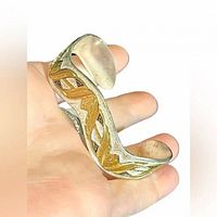 Full view of two-tone cuff bracelet on hand showing design and scale