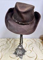 Front angled view of brown leather suede Western hat on stand