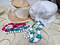 Overall lot showing two hats and bead necklaces