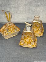 Three matching amber cut glass vanity pieces with floral cut pattern