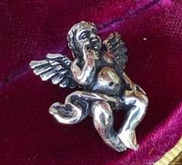 front view of cherub pendant on velvet background