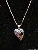 Close-up of sterling silver swirled heart pendant on box chain