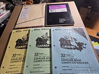 All items laid out: Blueline account book, Oxford ledger filler, three exercise books