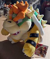 Front angled view showing Bowser plush with tag attached