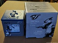 Photo cube beside original box showing front graphics and size