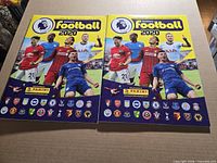 Front covers of both sticker albums showing identical graphics