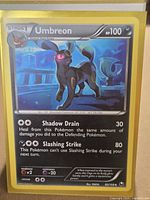 Front of Umbreon card in yellow sleeve showing artwork, HP, attacks, set info
