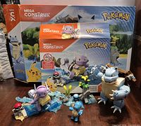 Overall lot showing Blastoise, Wartortle and Squirtle figures in front of both original Mega Construx Pokémon boxes and terrain pieces