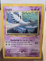 Front view of Lugia 20/64 holographic card showing artwork, 90 HP, attacks, and wear