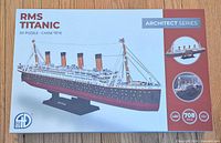 Front of sealed box showing product name, image of completed Titanic model, LED icon, piece count
