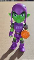 Front view of 9 cm Green Goblin figure holding orange pumpkin bomb