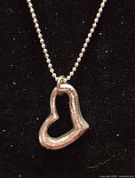 Front view of sterling silver open-heart pendant on bead chain