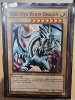 Front of Blue-Eyes White Dragon card inside sleeve showing name, artwork, stats and set code
