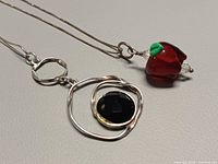 Both necklaces laid out showing pendants and chain style