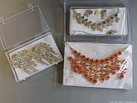 All three jewelry pieces in separate clear boxes